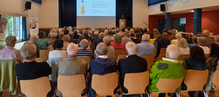 Viele ältere Menschen sitzen bei einem Vortrag